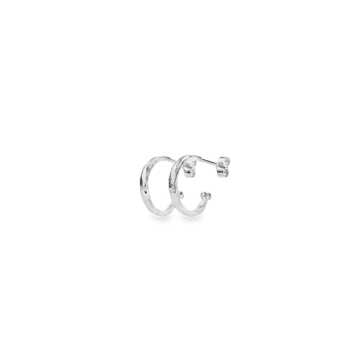 Silver mini hammered hoop earrings featuring a stunning texture, perfect for stacking and adding elegance to any outfit.