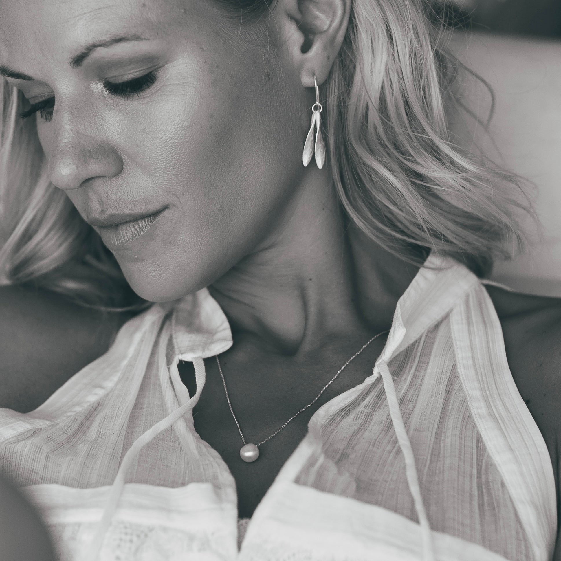 Model showcasing the Silver Double Leaf and Pearl Necklace Set with silver earrings and a pearl necklace.