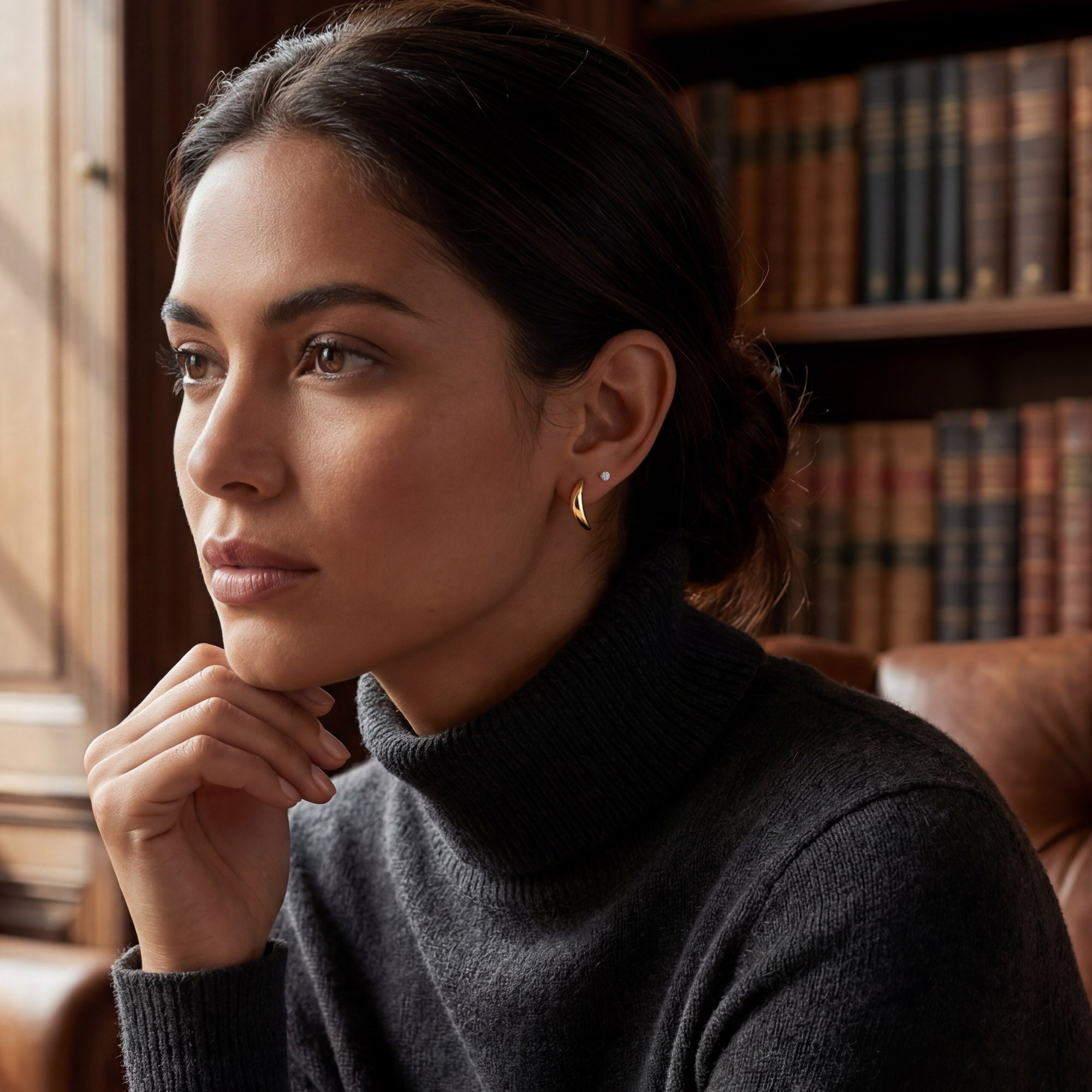 Gold banana-shape stud earrings in 18ct gold plated silver on woman's ear 