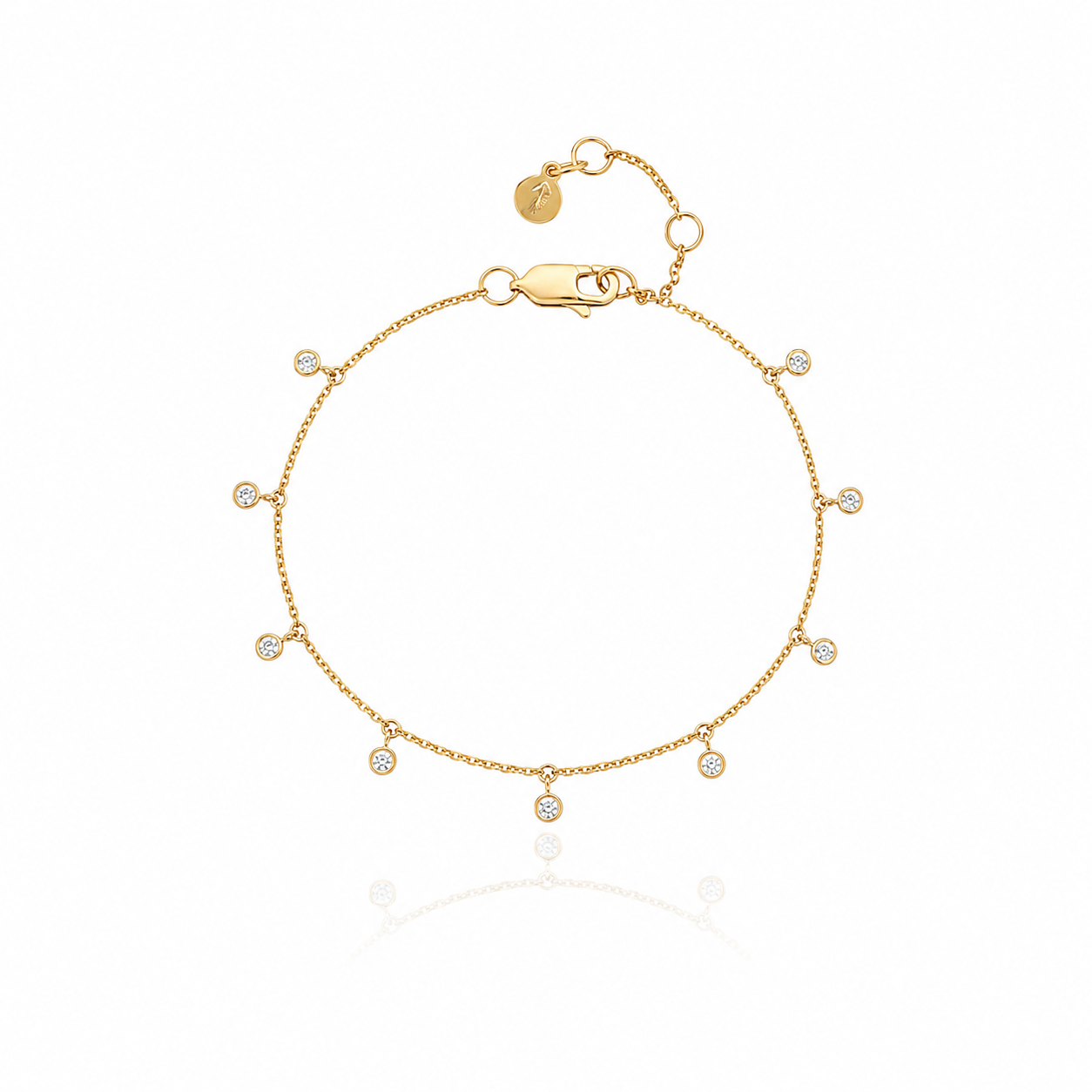 A delicate gold chain bracelet with small, evenly spaced round bezel-set clear cubic zirconia, displayed on a clean white background with a soft reflection below.