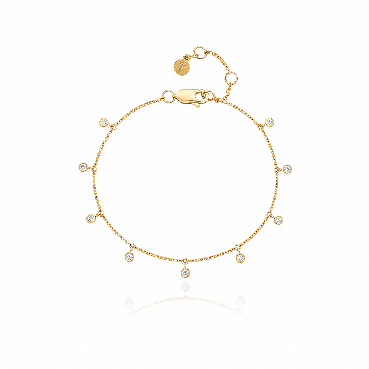 A delicate gold chain bracelet with small, evenly spaced round bezel-set clear cubic zirconia, displayed on a clean white background with a soft reflection below.