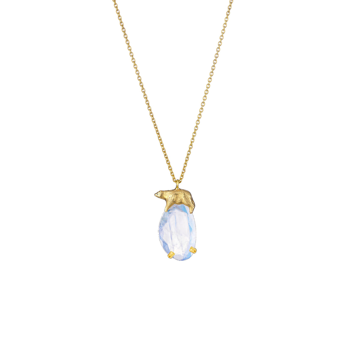 A gold pendant necklace featuring a small gold polar bear sitting on a faceted light blue moonstone, suspended from a delicate gold chain against a plain white background.