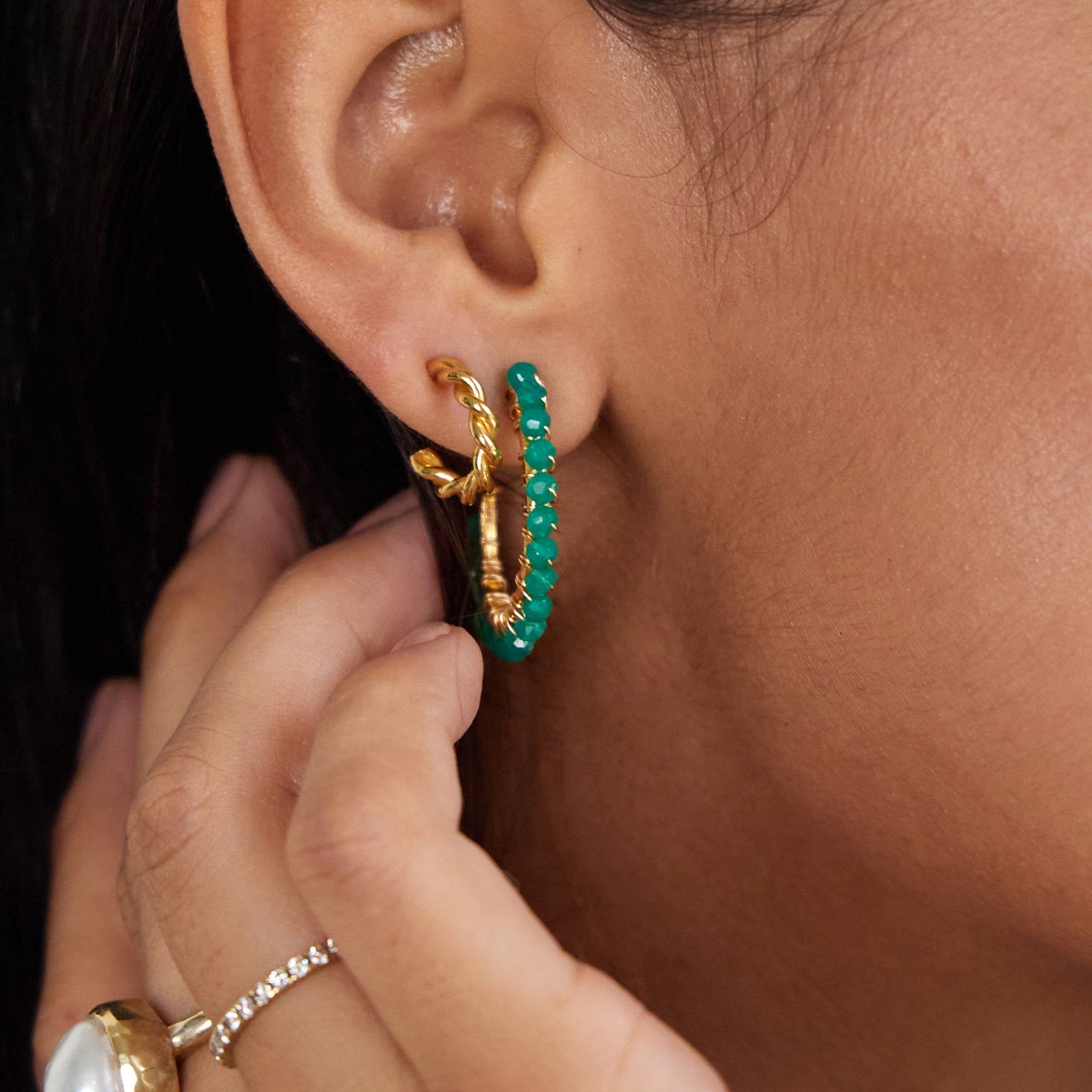 gold oak twist hoop earrings being worn with green agate hoop earrings