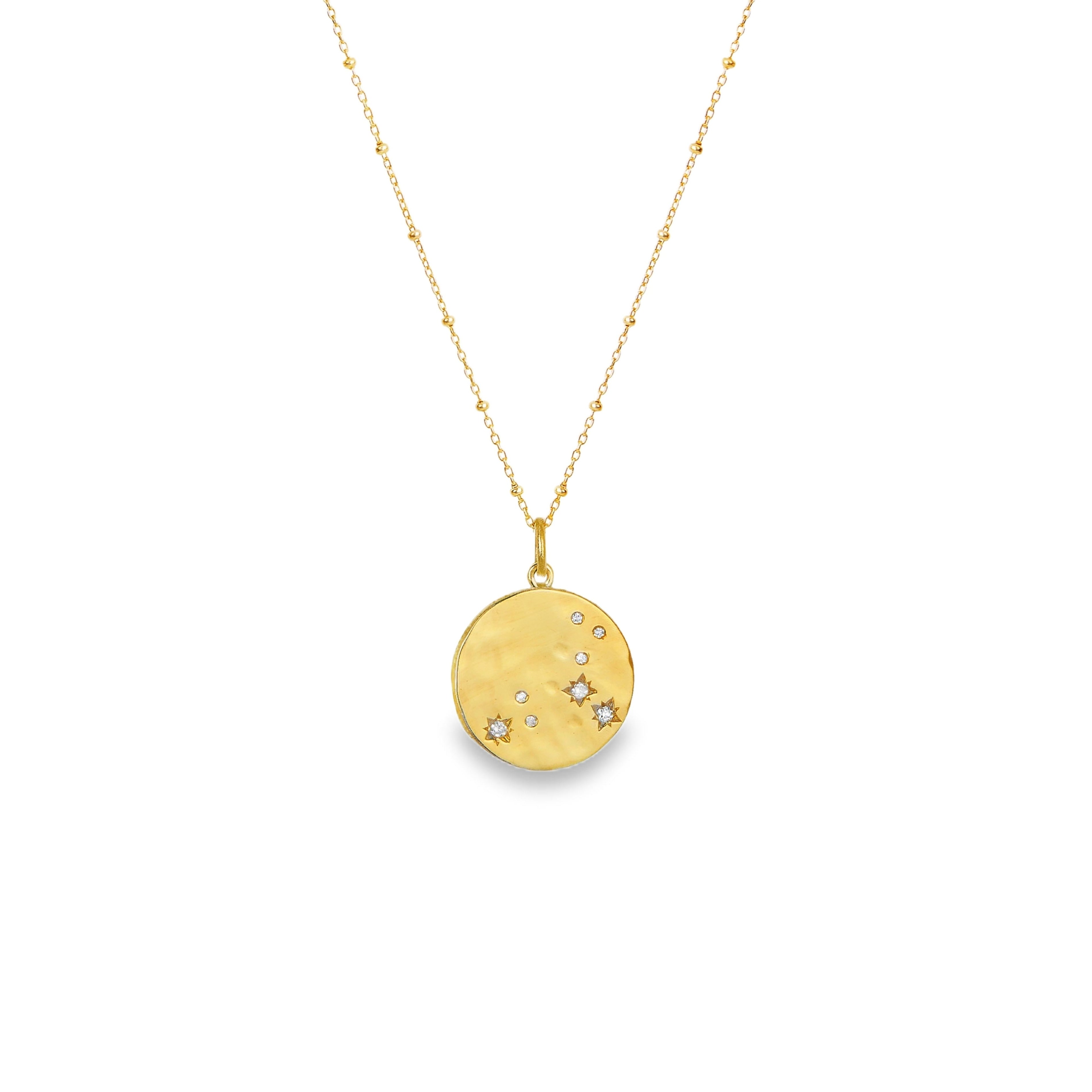 Gold hammered zodiac pendant featuring sparkling cubic zirconia on a hammered gold disc necklace.