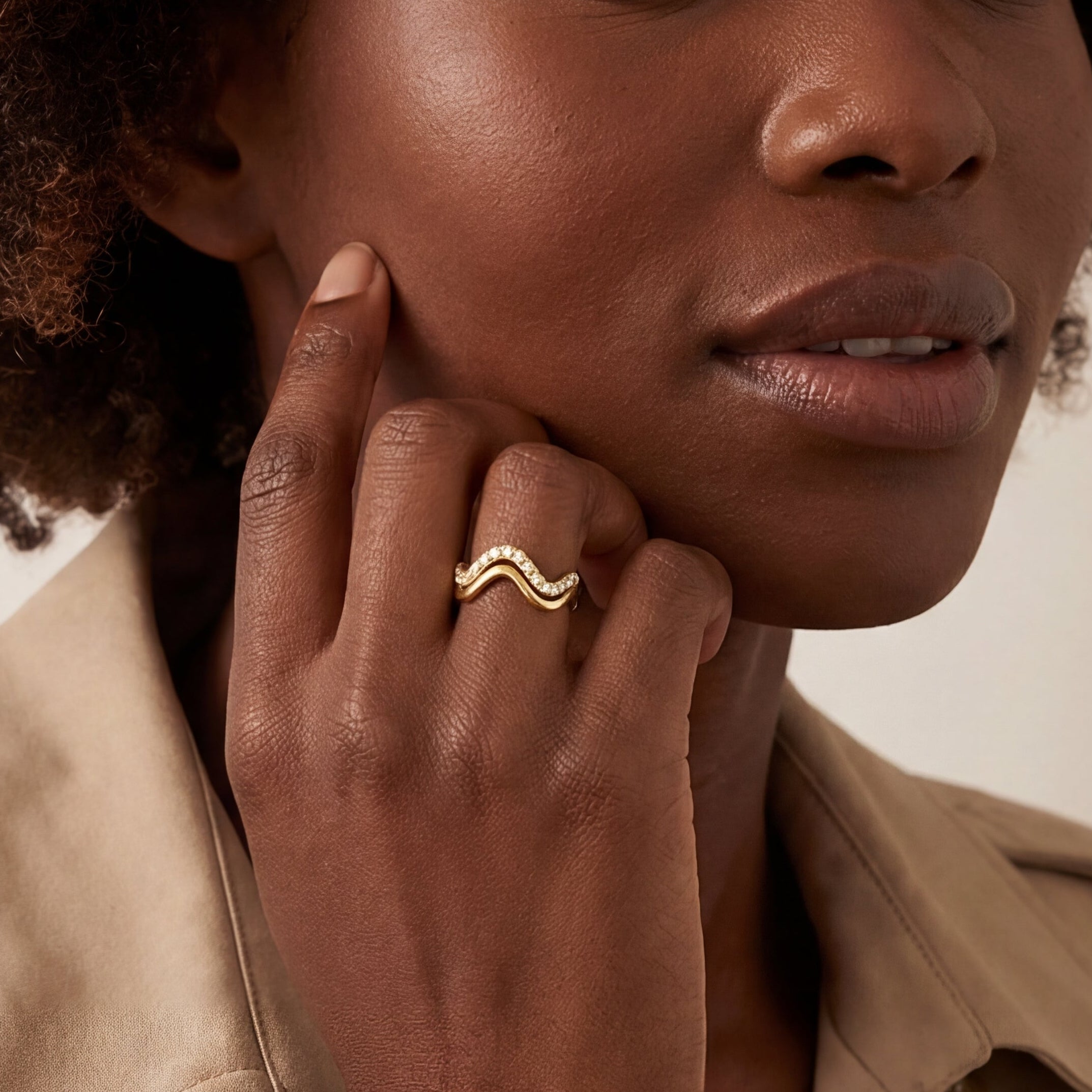 Close-up of a hand wearing the gold twinkle wave ring set, showcasing its elegant wave design and sparkling details.