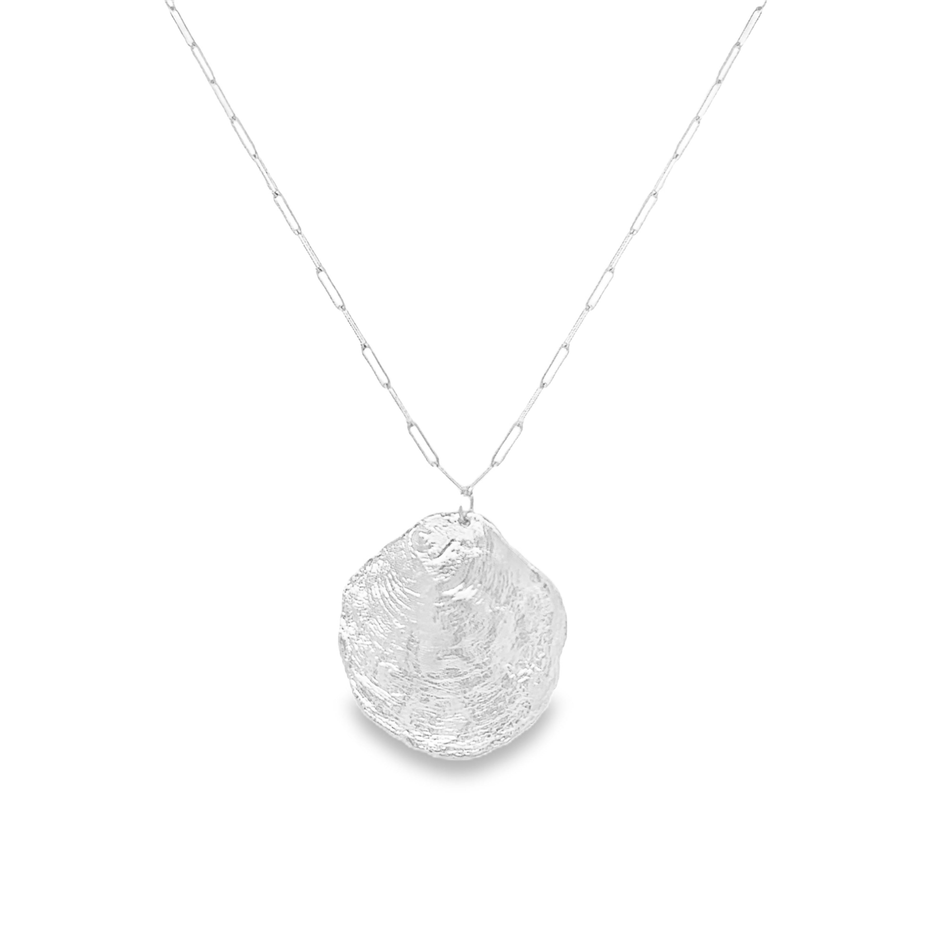 A silver paperclip chain necklace with a textured, organic-shaped silver shell pendant, shown against a plain white background.