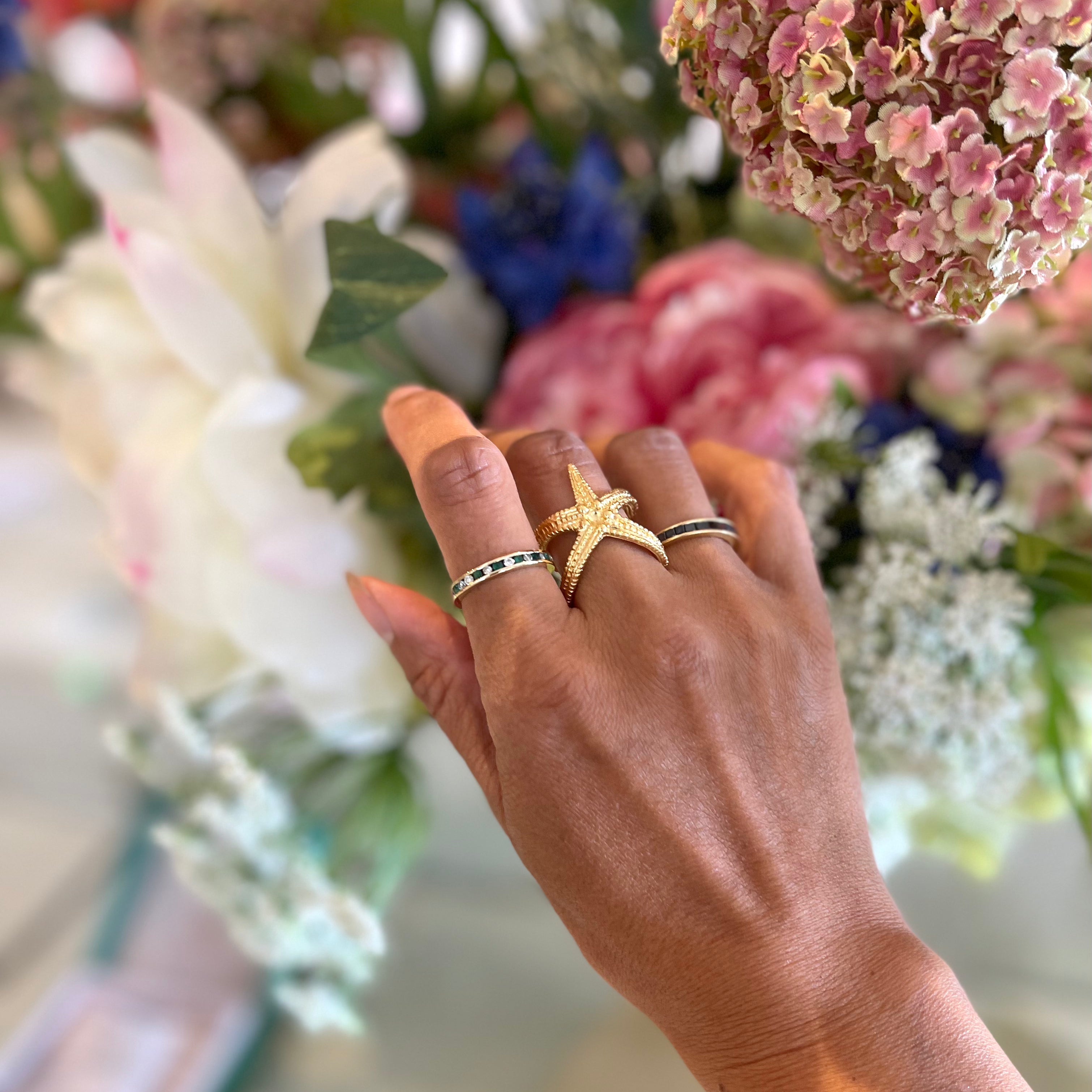 18ct gold plated silver adjustable starfish ring worn stacked on womans finger 