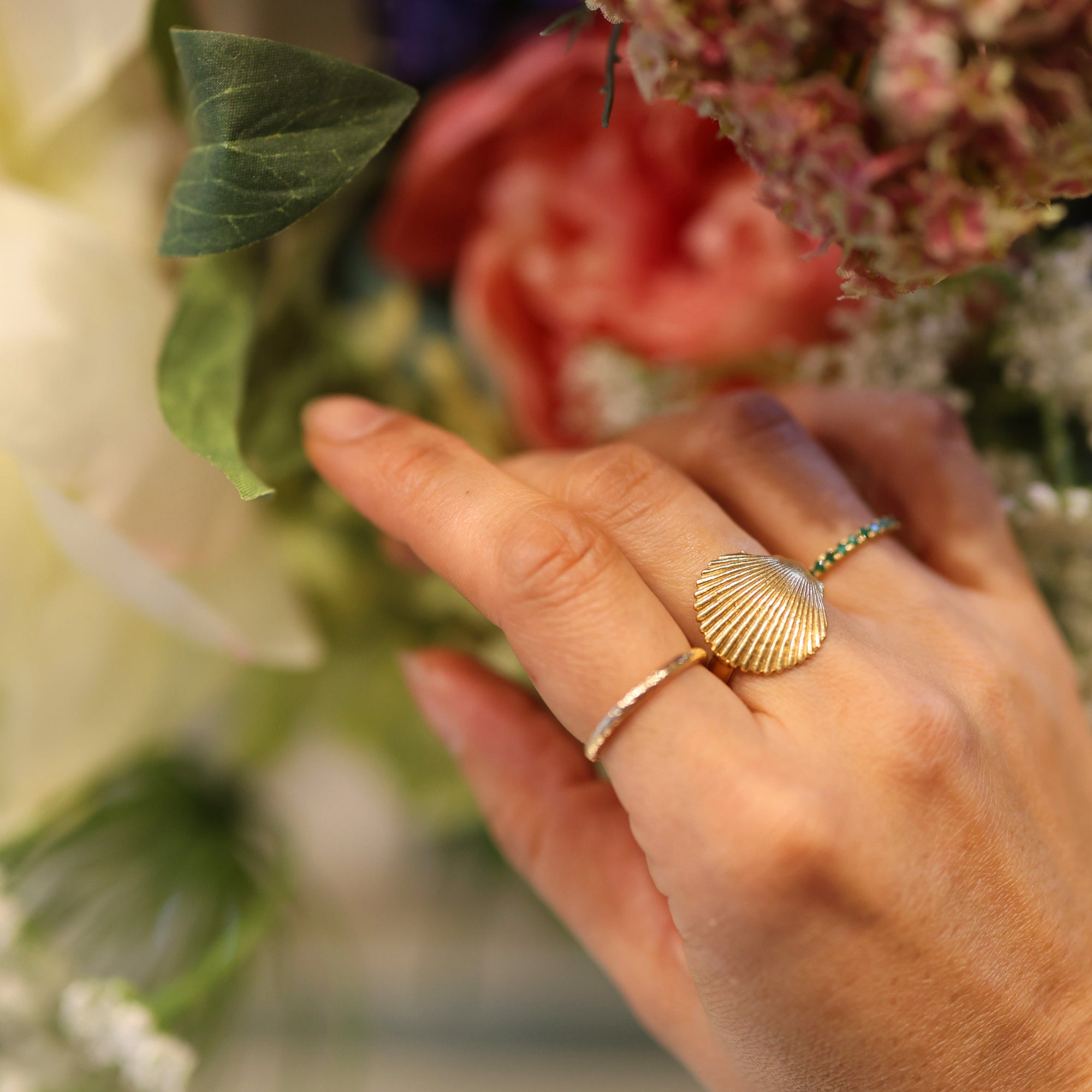 18ct gold plated silver scallop shell on a ring worn on womans hand 