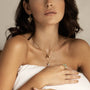 Gold fern drop earrings worn by a woman showcasing elegance and nature-inspired jewelry collection.
