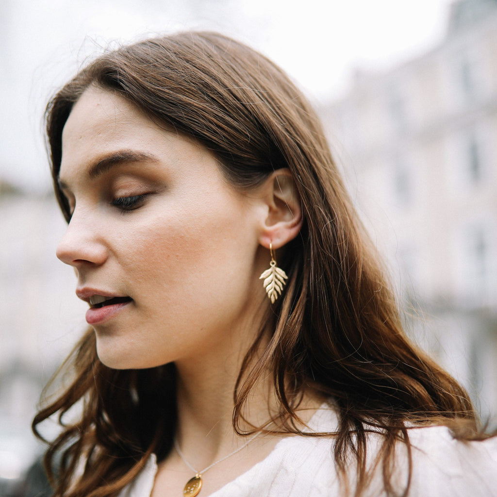 Model wears Catherine Zoraida Gold Fern Drop Earrings