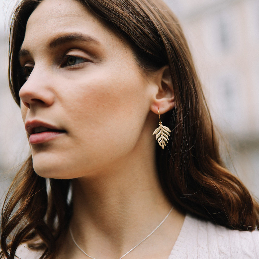 Model wears Catherine Zoraida Gold Fern Drop Earrings