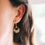 Gold Wee Fern Hoop Earrings showcased on a model's ear, featuring a delicate fern design in 18ct gold plated silver.