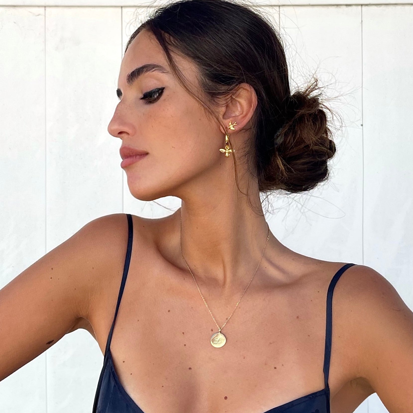9ct solid gold swallow stud earrings stacked on womans ear