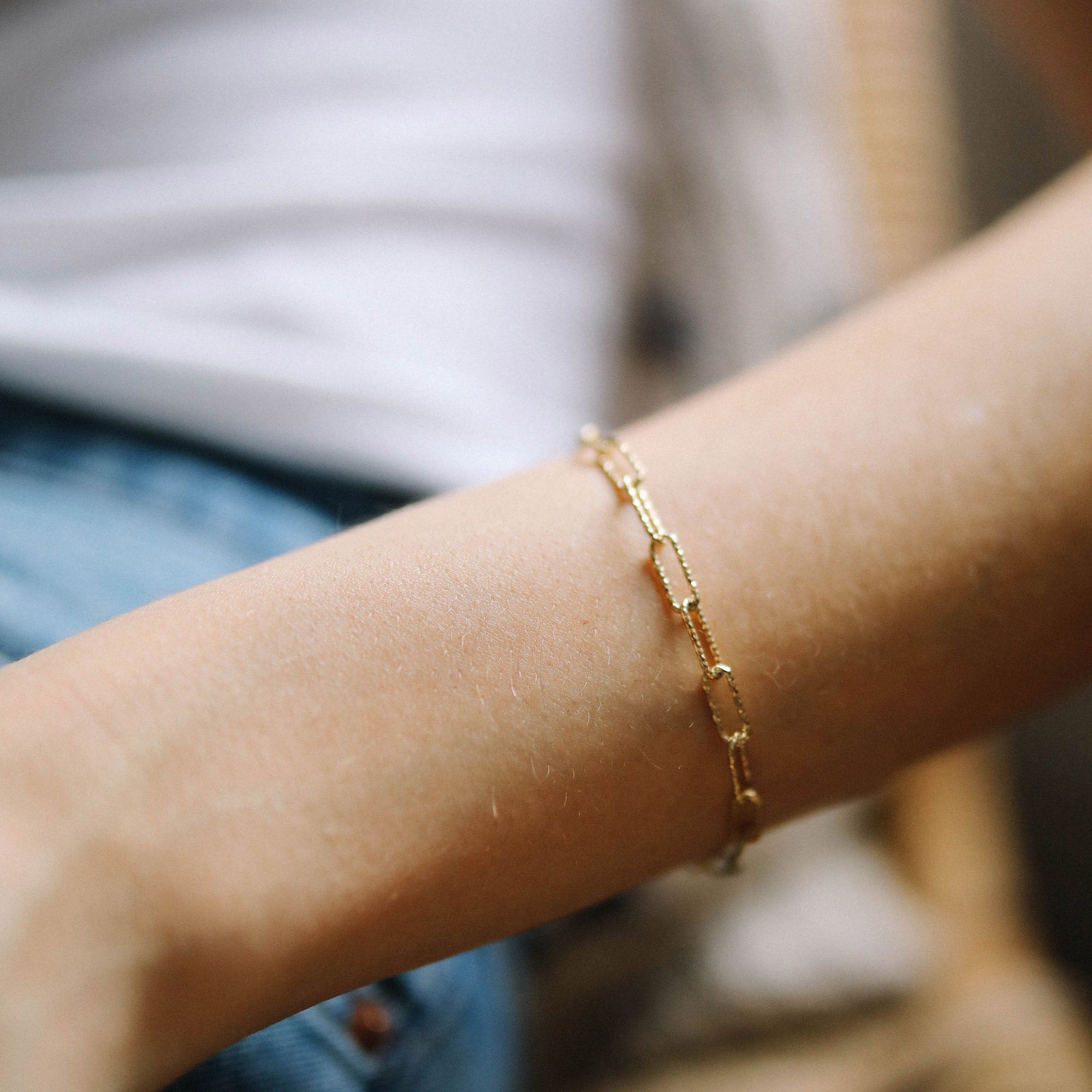 Close up of 18ct gold plated silver vermeil glitter chain bracelet worn on womans wrist