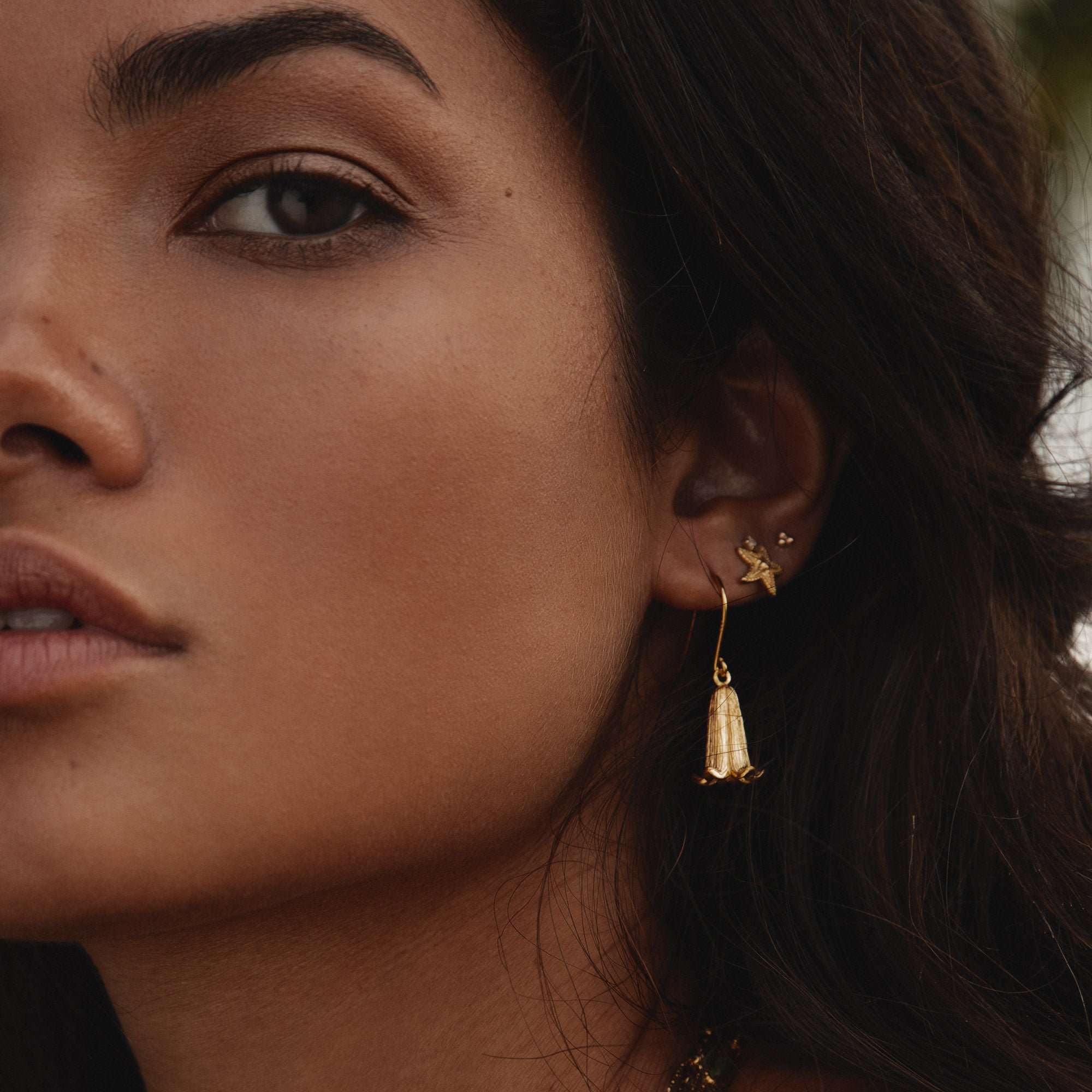 Close-up of a model wearing Silver Starfish Stud Earrings and elegant gold earrings.